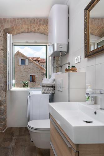 a bathroom with a toilet and a sink and a window at Studio Amore in Diocletian palace in Split