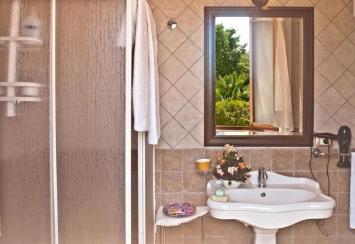 a bathroom with a sink and a mirror at Agriturismo Sa Suerera in Olmedo