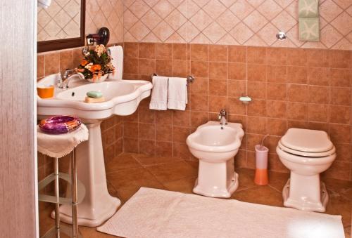 a bathroom with a sink and a toilet and a sink at Agriturismo Sa Suerera in Olmedo