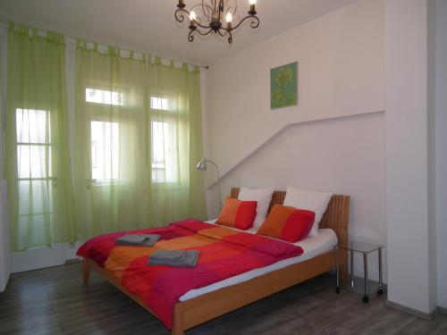 プラハにあるOld Town spacious apartmentのベッドルーム1室(大型ベッド1台、赤とオレンジの枕付)