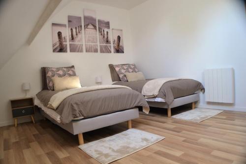 1 dormitorio con 2 camas y un cuadro en la pared en Sur la route de champ colin, en Saint-Denis-lès-Rebais