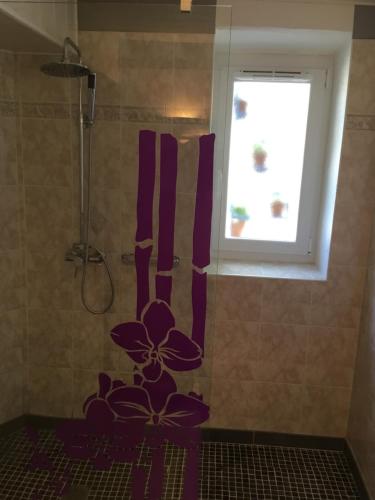 La salle de bains est pourvue d'une douche avec une fleur peinte au mur. dans l'établissement Les Palettes, à Salavas