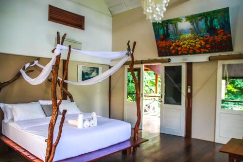 two beds in a room with a painting on the wall at Serene Beach Villa in Gili Trawangan