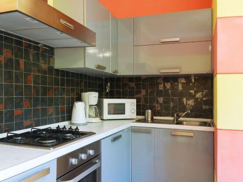 a kitchen with blue cabinets and a sink and a microwave at Casa Ponte Ballerino in Cannobio