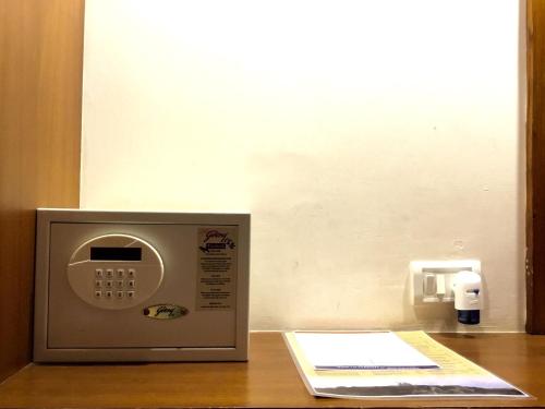 a microwave sitting on top of a wooden table at Sai Towers in Puttaparthi
