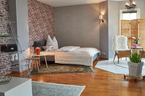 - une chambre avec un lit et un mur en briques dans l'établissement Taunushome, à Bad Camberg