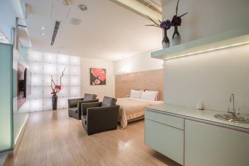 a bedroom with a bed and a couch and chairs at Motel Stars in Taichung