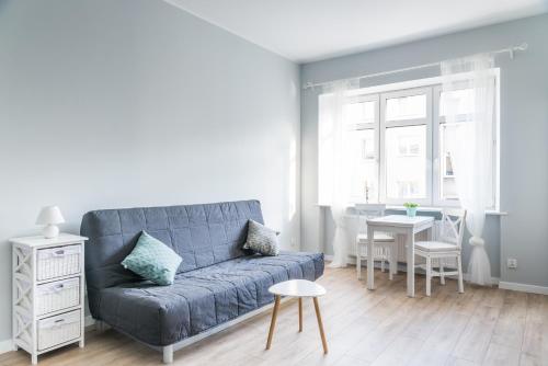グディニャにあるMieszkanie w Ścisłym Centrum Gdyniのリビングルーム(青いソファ、テーブル付)