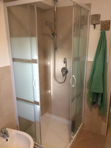 une douche avec une porte en verre dans une salle de bain dans l'établissement Casamare Lido di Noto, à Noto Marina