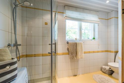 a bathroom with a shower and a toilet and a window at Lahe apartment in Haapsalu