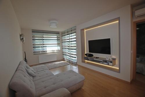 a living room with a couch and a flat screen tv at Silver DeLux Apartman in Balatonfüred