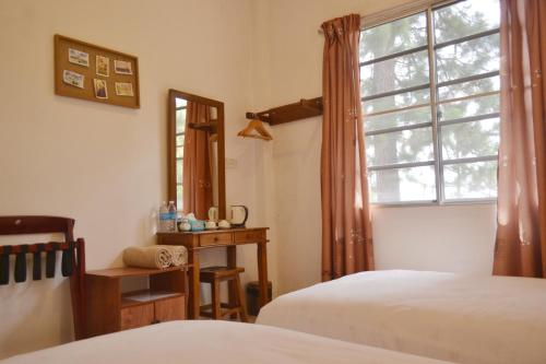 a bedroom with two beds and a window at Skyville Zen Resort,Kundasang in Kundasang