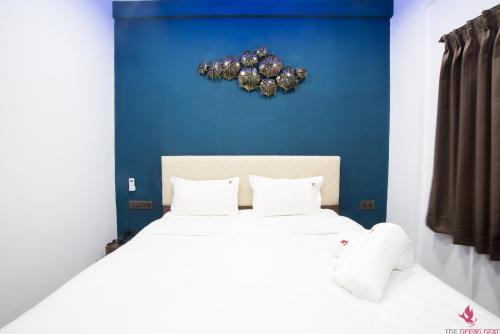 a bedroom with a white bed with a blue wall at The Urban Nest in Bangalore