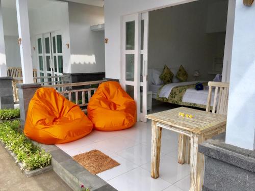 a bedroom with two orange bean bags and a bed at Narayana Homestay in Amed