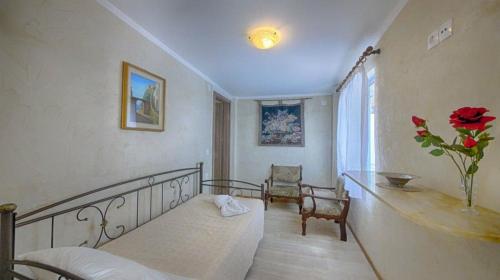 Zimmer mit einem Bett und einer Blumenvase in der Unterkunft Feakia apartment 1 in Agios Gordios
