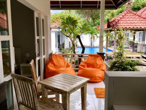 a patio with a table and chairs and a pool at Narayana Homestay in Amed