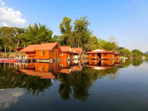 a group of houses on a river with reflections in the water at Pae Maldive Erawan in Chongsadao