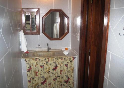 a bathroom with a sink and a mirror at Pousada Bangalô in Jericoacoara