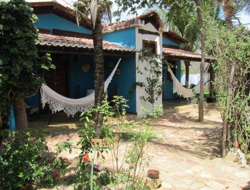 a blue house with a hammock in front of it at Pousada Bangalô in Jericoacoara