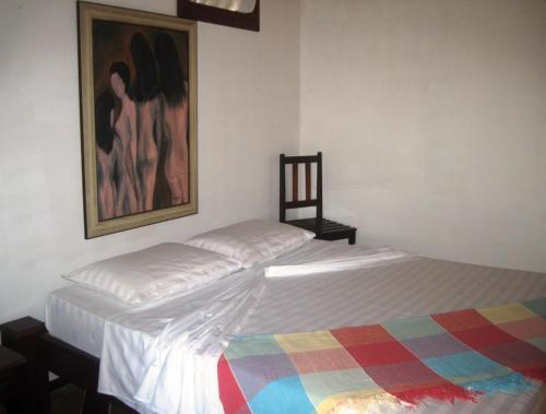 a bedroom with two beds and a painting on the wall at Pousada Bangalô in Jericoacoara