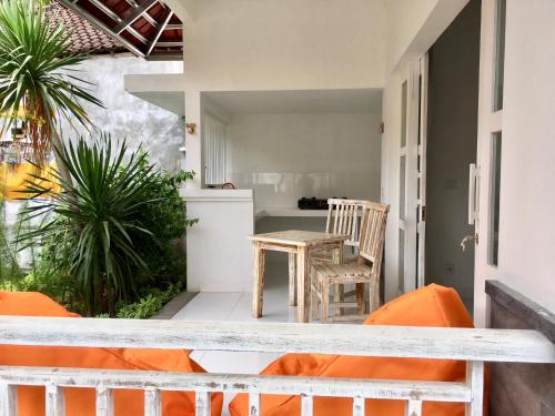 a balcony with a table and chairs and a kitchen at Narayana Homestay in Amed