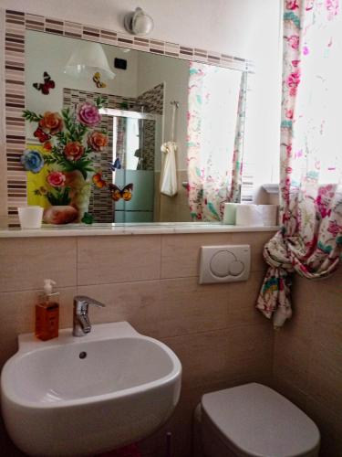 a bathroom with a sink and a toilet and a mirror at Sally's B&B in Carrara