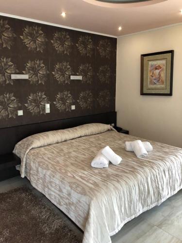 a bedroom with a large bed with two pillows on it at Selefkos Palace in Igoumenitsa