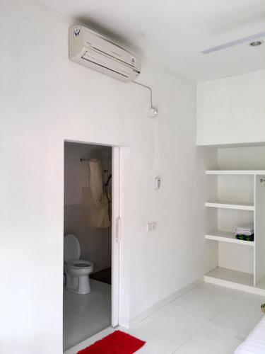 a bathroom with a toilet and a ceiling fan at Narayana Homestay in Amed