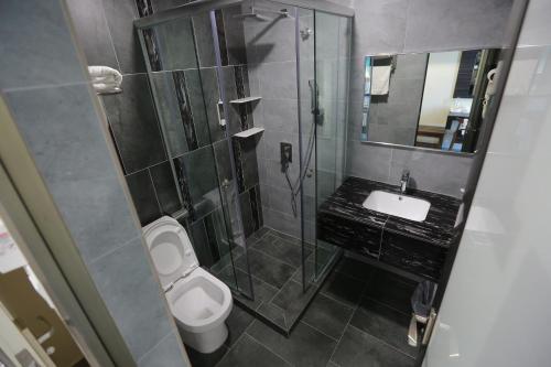 a bathroom with a shower and a toilet and a sink at Pantai Regal Hotel in Kuantan