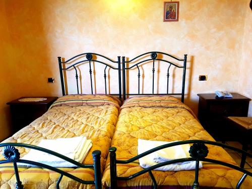a bedroom with a bed with a yellow comforter at Hotel Villa Elisabetta in Galatina