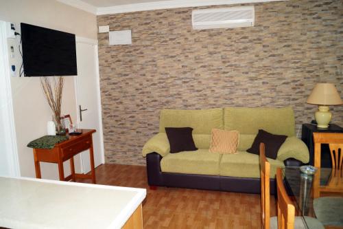 a living room with a couch and a brick wall at Casa Rural El Nacimiento in Benaoján