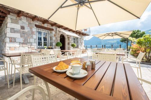 a wooden table with a cup of coffee and food on it at Garden View in Anfo