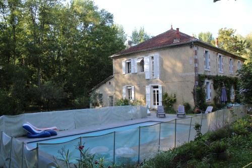 une maison avec une piscine devant une maison dans l'établissement Les Mouleres, à Mauvezin