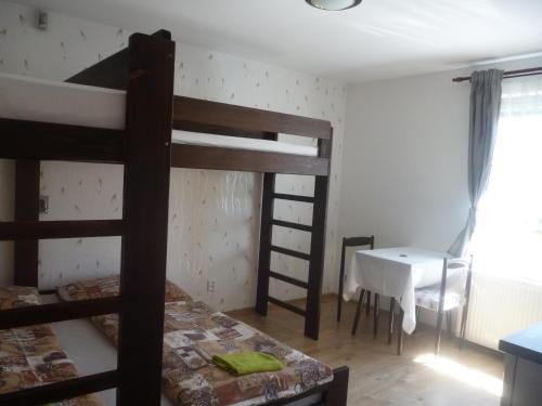 a bedroom with two bunk beds and a desk at Pension Pugner in Vysoké nad Jizerou