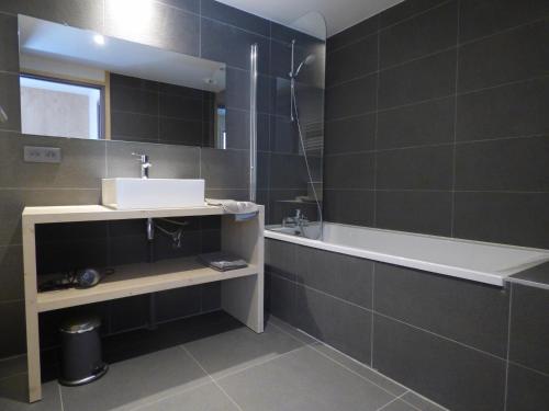 a bathroom with a sink and a bath tub at Le Refuge de Montgésin in Aime-La Plagne