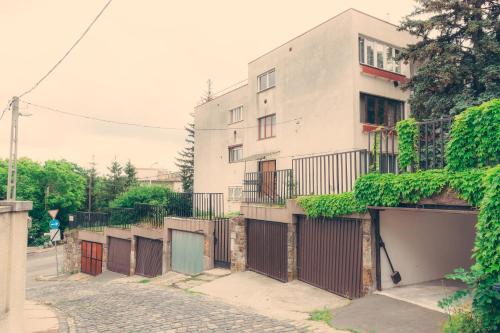 a white building with a gate and a brick street at Apartment on Gellért Hill Budapest Downtown with free garage & Castle View in Budapest