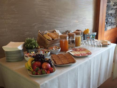 a table topped with plates of food and fruit at Garden View in Anfo