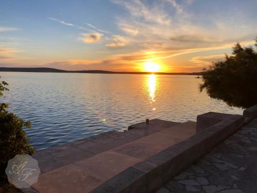 a sunset over a large body of water at Apartmani Ferdinanda in Kustići