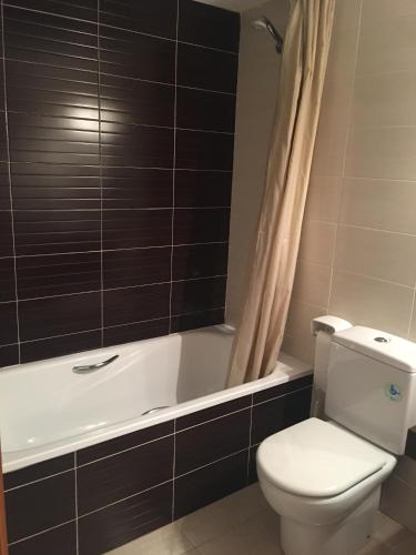 a bathroom with a white toilet and a bath tub at Apartamento en Benicarlo in Benicarló