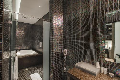a bathroom with a shower and a sink and a tub at Motel Stars in Taichung