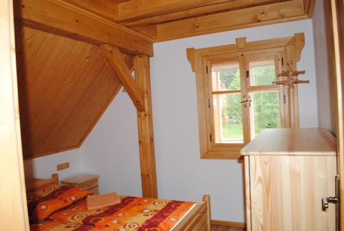 a bedroom with a bed and a window at Roubenka-Mila in Ostružná