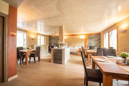 a kitchen and dining room with wooden tables and chairs at Garden View in Anfo