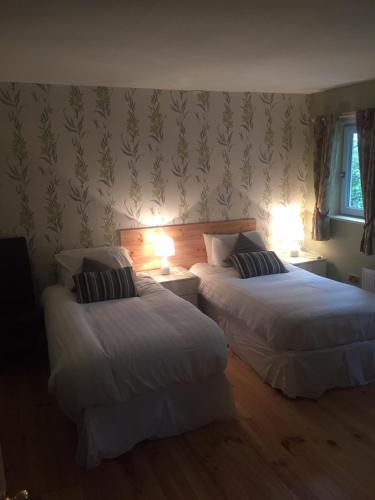 two beds in a room with lights on the wall at A Selection of Self Catering Holiday Homes at Kilcloon Cottages in Maynooth