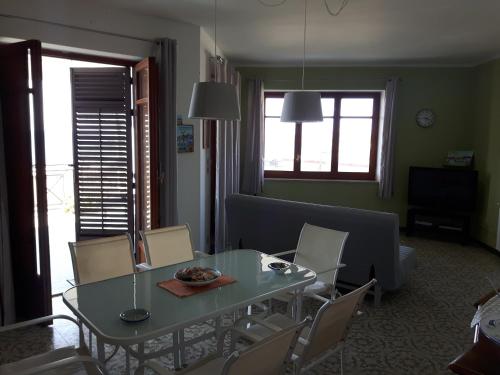 ein Wohnzimmer mit einem Glastisch und Stühlen in der Unterkunft Villa le Due Palme in Isola delle Femmine