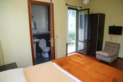 a bedroom with a bed and a bathroom with a toilet at Aşiyan Butik Hotel in Buyukada