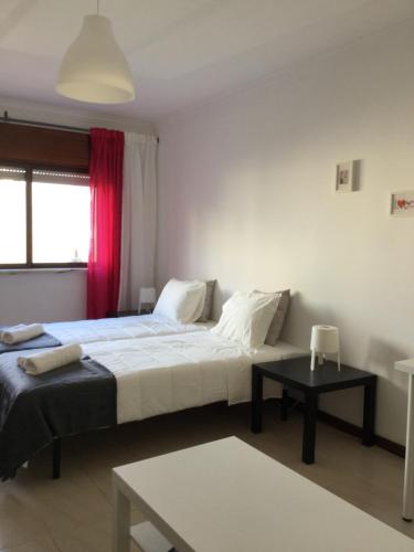 a bedroom with two beds and a table at APARTAMENTO LISBOA - REBOLEIRA in Amadora