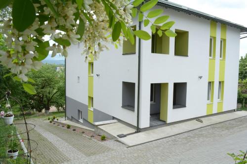 a white building with green and yellow windows at Guest House at Lesya Ukrainka in Truskavets