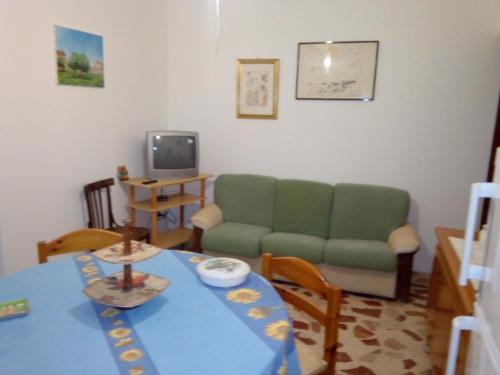 Ioppolo Giancaxio的住宿－La piazza piccola alle spalle Del castello，客厅配有绿色沙发和桌子