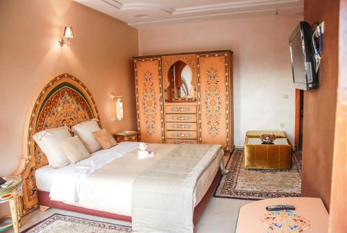 a bedroom with a bed and a dresser at Riad Noumidya in Fès