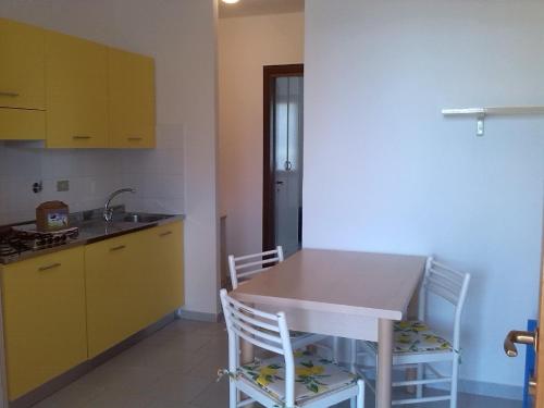 a kitchen with yellow cabinets and a table and chairs at Casa Del Golfo in Lacona